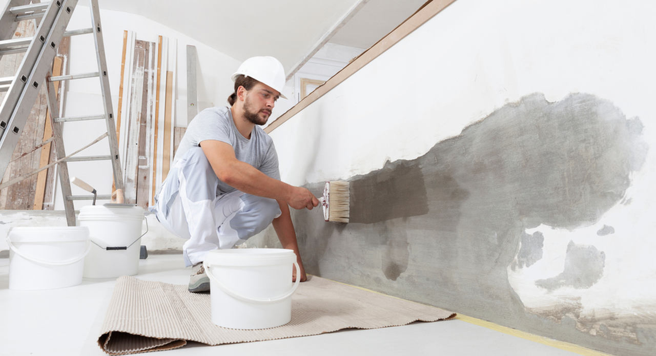 worker applying primer paint