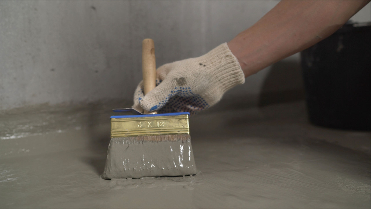 worker fixing the waterproofing insulation with a brush