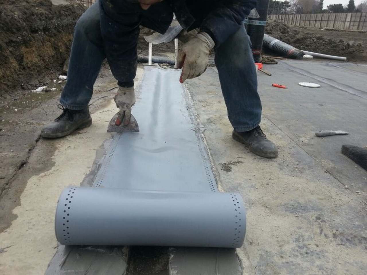 worker who is applying expansion joint tape onto the floor