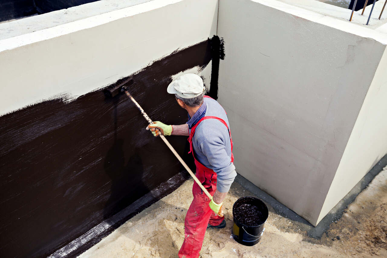 worker applying water insulation to the exterior wall