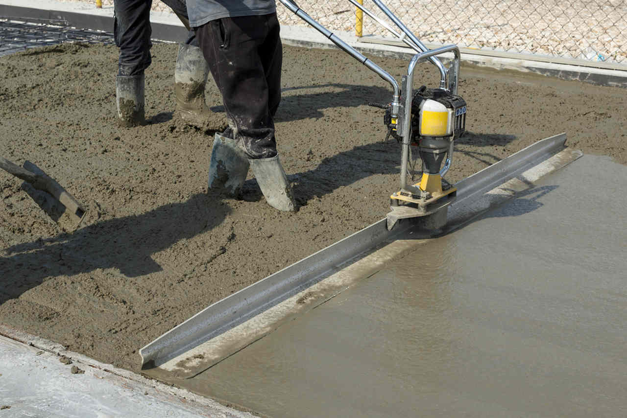 makine ile beton düzleştiren işçiler