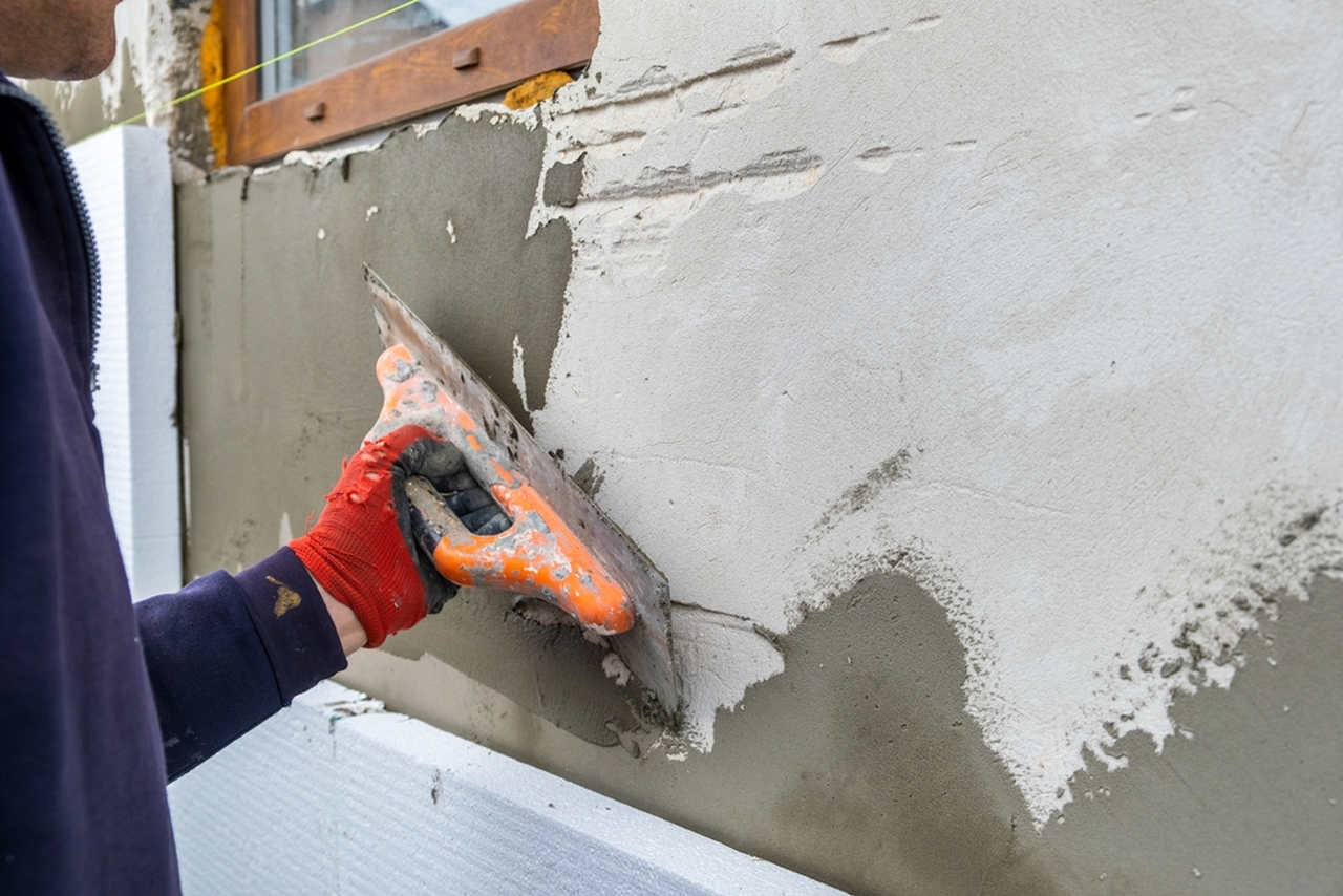 lavoratore che applica l'isolamento sul muro