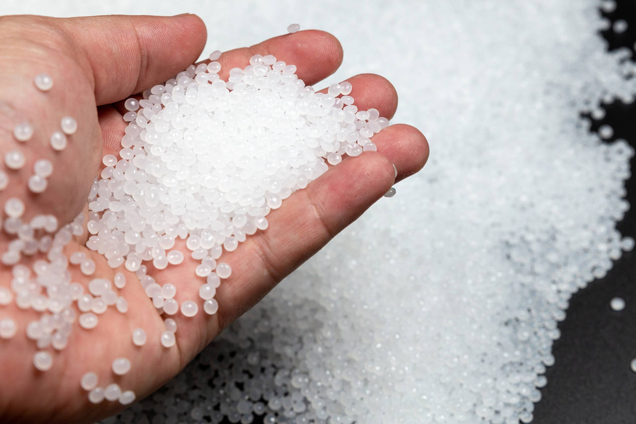 man holding little polymer pieces