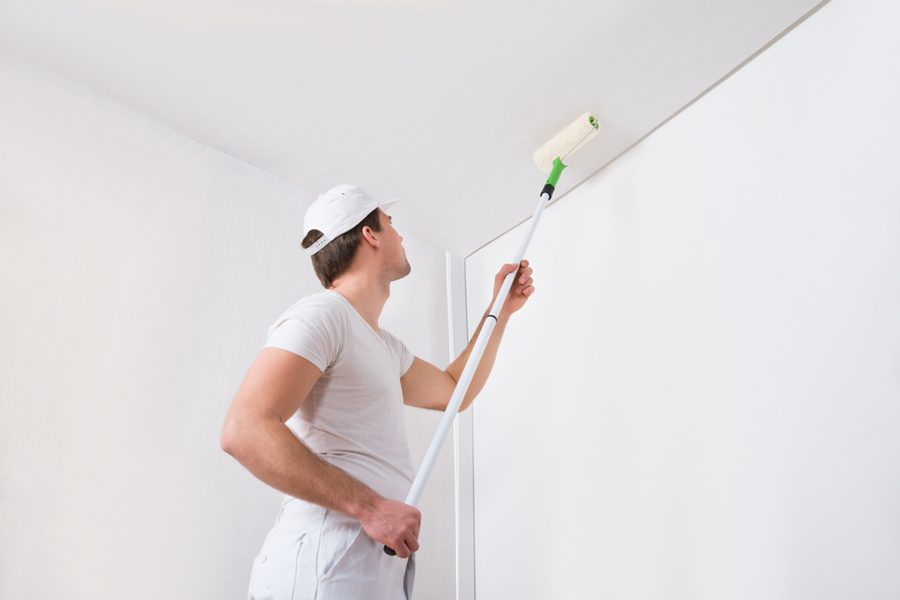 worker painting the corner of the ceiling