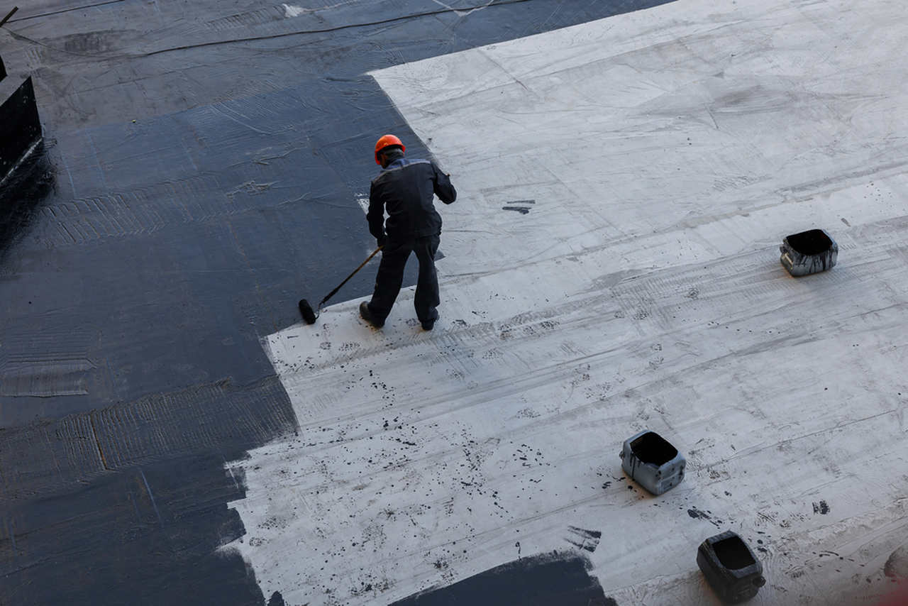 worker applying water insulation to the top